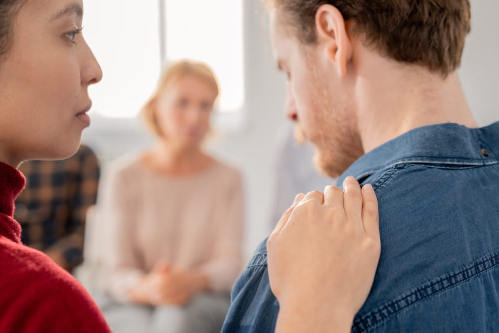 Femme avec main sur l'épaule d'un homme